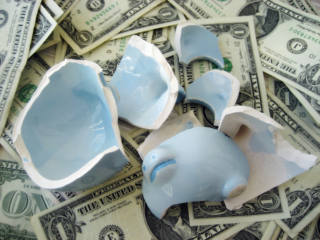 broken piggy bank of one dollar bills